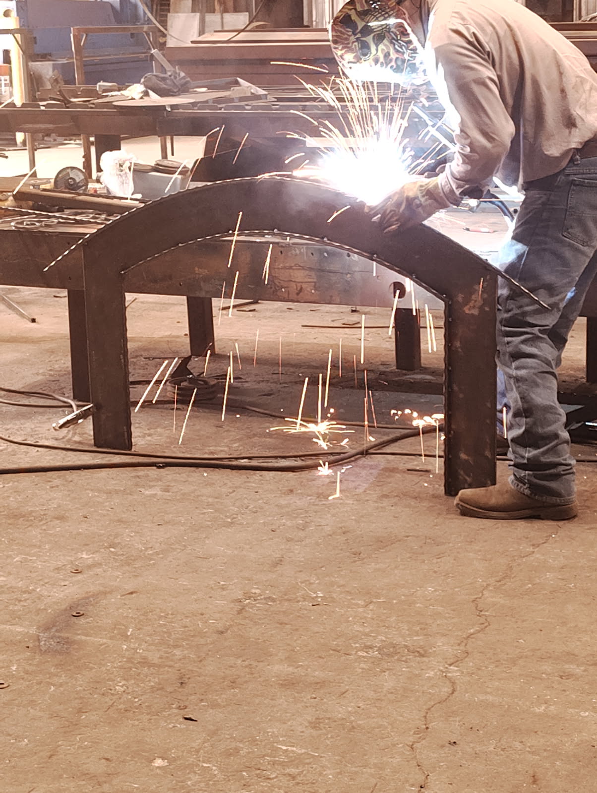 Welder fabricating a custom steel fireplace surround for a Houston, TX home