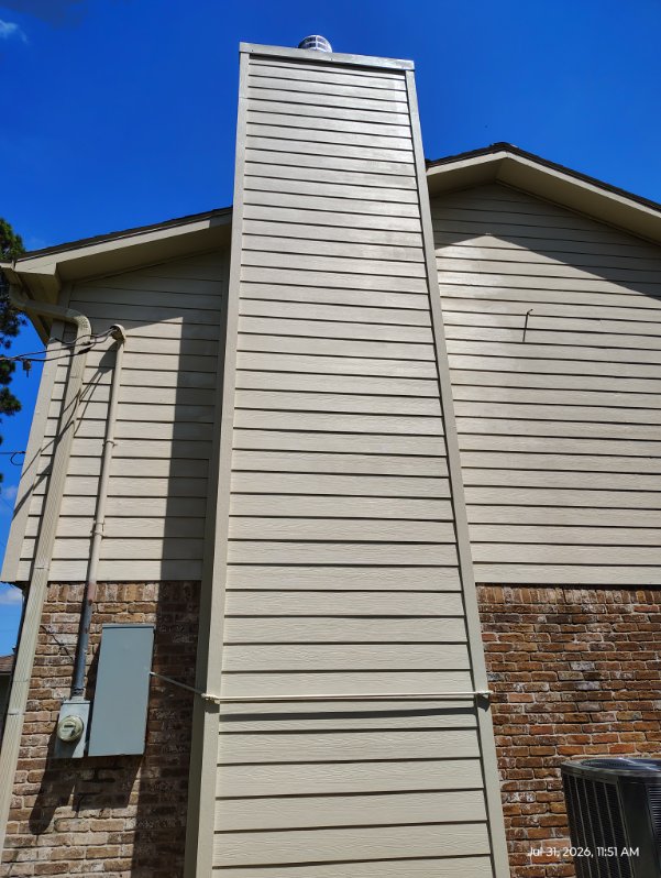 Rebuilt chimney chase with new siding and flashing on a Houston, TX roofline