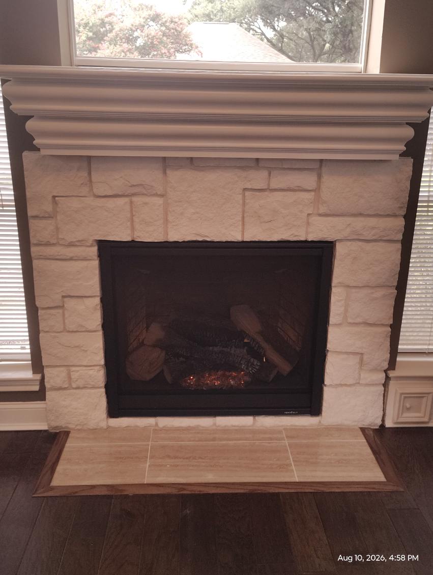 Cut stone fireplace with gas insert, painted mantel and tile hearth in Tomball, TX