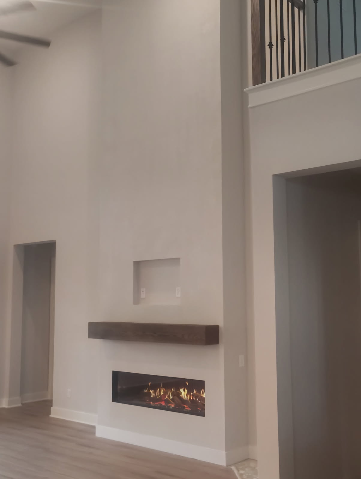 Linear gas fireplace with floating wood mantel in The Woodlands, TX