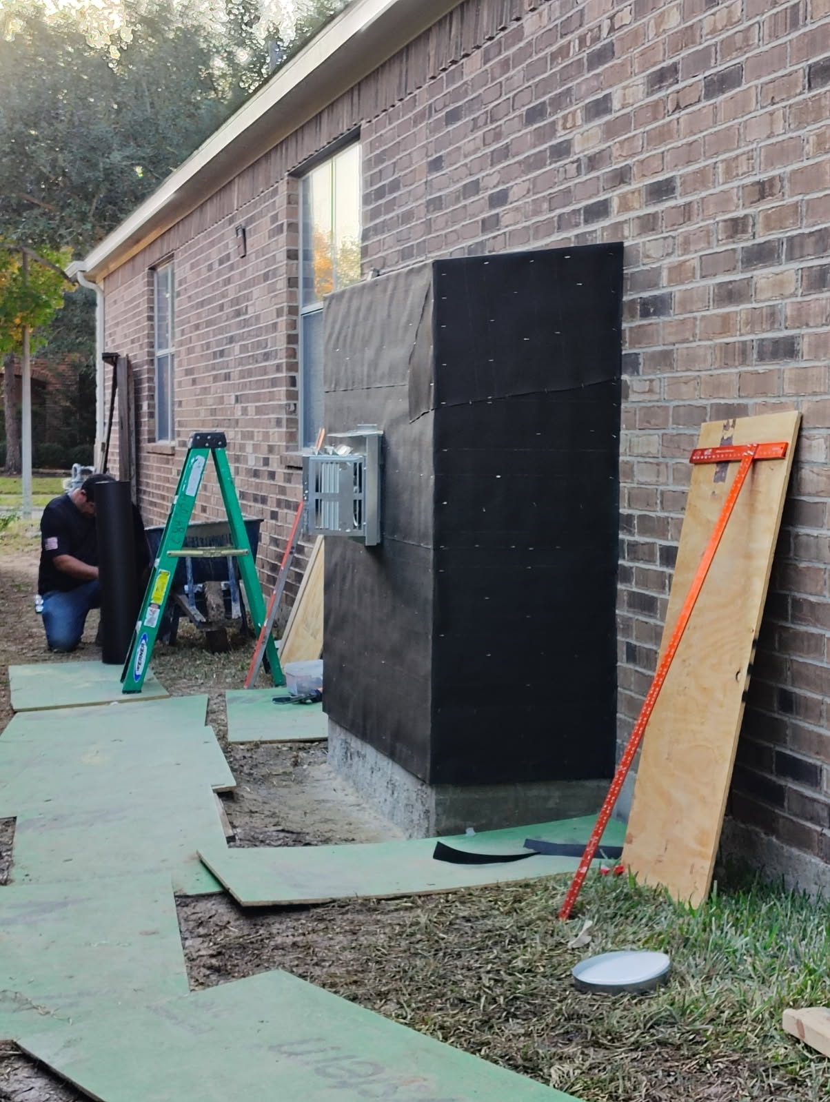 Outdoor fireplace under construction on a backyard patio in Houston, TX
