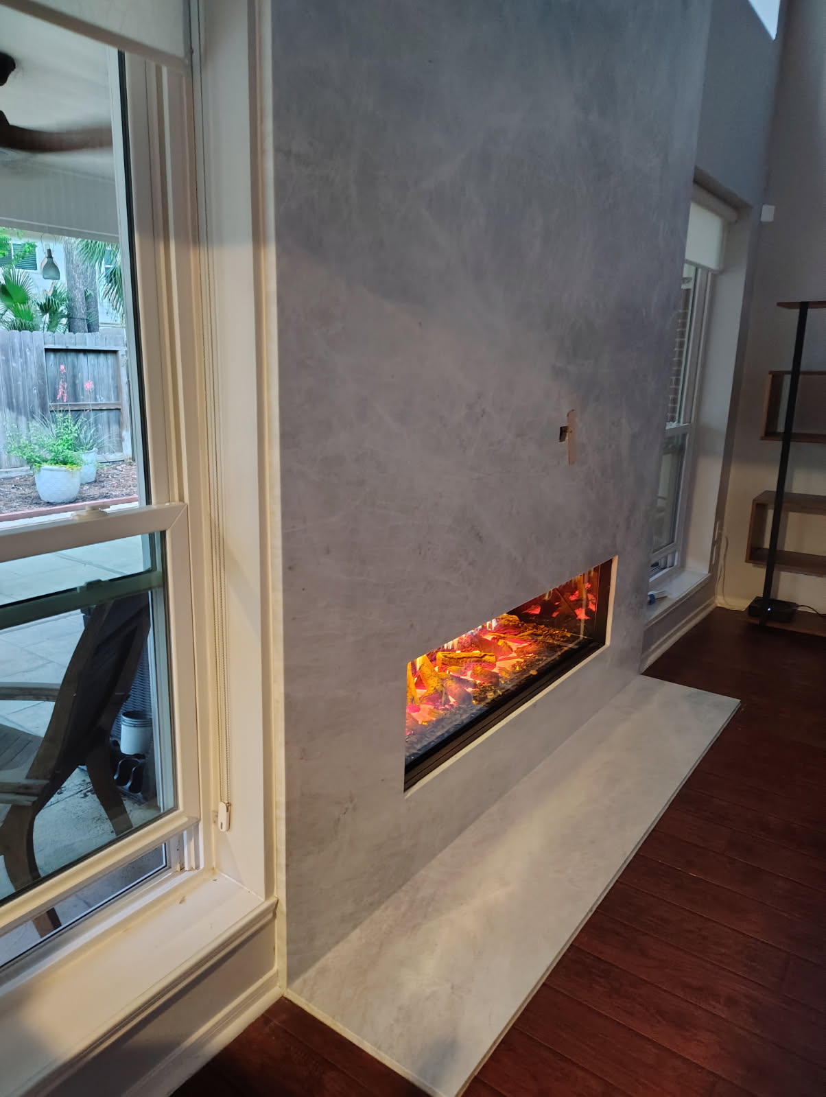 Linear electric fireplace set into a micro-cement wall in Houston, TX