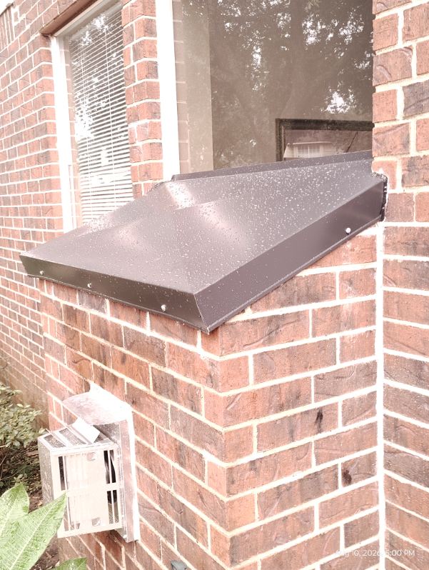 Close-up of a freshly installed chimney chase cover shroud on a brick chase in Houston, TX