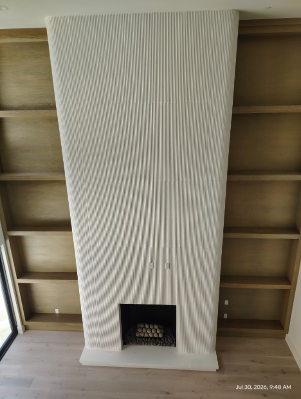 Floor-to-ceiling plaster fireplace with custom built-ins in Cypress, TX